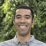 A person smiling with a leafy backdrop, representing digital healthcare for Medbridge.