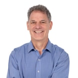 Confident man in a blue dress shirt with arms crossed, representing digital healthcare and medbridge.
