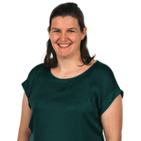 A smiling woman with shoulder-length brown hair in a dark green top stands against a plain background, representing medbridge.