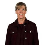 Smiling woman with light hair in maroon stands against a white background, representing medbridge healthcare education.