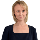 Blonde woman in a dark square-neck top stands before a white background, representing the future of digital healthcare at medbridge.