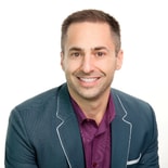 A man in a teal blazer smiles against a white background, representing innovation at medbridge.