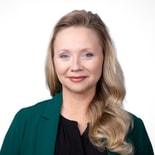 Smiling woman with long blonde hair in a green blazer, representing the future of digital healthcare with medbridge.