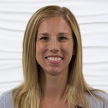 A smiling person with long blond hair symbolizes compassionate hybrid care by Medbridge.