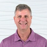 A smiling man in a purple polo represents Medbridge's bright future in digital healthcare.