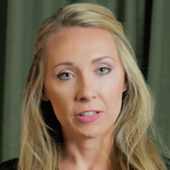 A woman with long blonde hair stands in front of a dark green curtain, representing hybrid care for Medbridge.