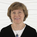 A smiling woman with short hair stands against a wavy white background, representing Medbridge's digital healthcare innovation.