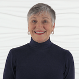 A confident person with short gray hair smiles against a wavy white background, representing Medbridge and their digital healthcare expertise.
