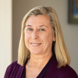 A smiling woman with blonde hair and a maroon top represents Medbridge's warm hybrid care approach.