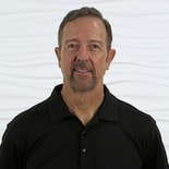 A man in a black shirt stands against a white background, symbolizing digital healthcare integration with medbridge.