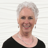 A smiling individual with short white hair represents Medbridge healthcare education against a white background.