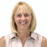 A smiling woman with shoulder-length blond hair in a beige sleeveless blouse embodies Medbridge's healthcare education spirit.