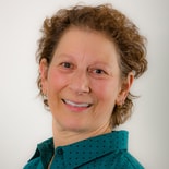 A smiling person in a teal polka dot shirt, symbolizing Medbridge healthcare training friendliness.
