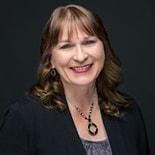 A smiling woman with brown hair and a black blazer is pictured in front of a dark background, associated with medbridge.
