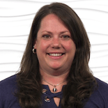 A smiling person with long brown hair in a navy top symbolizes Medbridge's impact on digital healthcare.