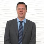 Businessman in a suit and tie against textured white background for medbridge.