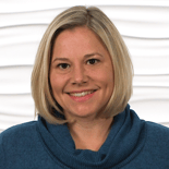 A smiling person with short blond hair in a blue sweater represents modern digital healthcare, symbolizing warmth and innovation, for medbridge.