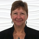 Person with short hair in a black jacket and earrings represents hybrid care, set against a white textured background.
