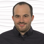 A bearded man in a dark shirt smiles confidently, with healthcare training at medbridge against a wavy white background.