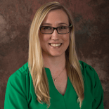 A smiling person with long blonde hair and glasses in a green top represents the future of digital healthcare for Medbridge.