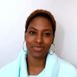 Person with short hair and hoop earrings in a light blue top, symbolizing digital healthcare's evolving role.