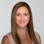 A smiling individual with long hair and a necklace represents digital healthcare for medbridge.