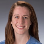 A woman with long brown hair in a blue shirt smiles, representing medbridge's vision for digital healthcare.