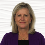 A woman with blonde hair and a purple cardigan stands against a white background, representing Medbridge's digital healthcare innovation.