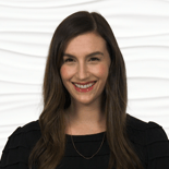 A woman smiling in front of a wavy white background representing medbridge's innovation in digital healthcare.