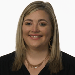 A healthcare educator with shoulder-length blonde hair smiles, wearing a black top and gold jewelry against a white background for Medbridge.