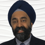 A bearded man in a suit and dark turban smiles confidently, embodying medbridge's healthcare education mission.