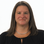 A smiling person with long brown hair wears a black top and silver necklace against a white background, following Medbridge guidelines.