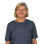 Smiling middle-aged woman with short blond hair in a grey t-shirt, representing digital healthcare and hybrid care at medbridge.