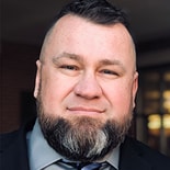 A bearded man in a suit represents Medbridge's vision for digital healthcare.