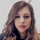 A person with long, wavy hair looks at the camera, representing digital healthcare innovation for medbridge.