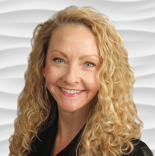 Woman with curly blonde hair smiling in a black top against white texture.