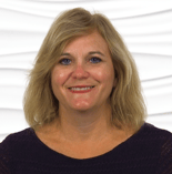 Medbridge employee with blonde hair and a black top smiles against a wavy white background.
