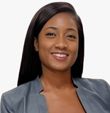 A woman with long dark hair in a gray blazer smiles at the camera, representing digital healthcare professionalism at medbridge.