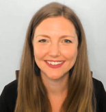 Person with long brown hair smiles against a plain light gray backdrop for medbridge.