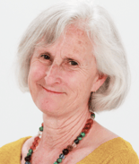 A smiling older woman with short white hair, wearing a necklace and mustard top, representing medbridge's patient care focus.