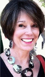A smiling woman wearing a large metallic necklace reflects her newfound confidence from medbridge healthcare training.