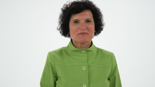 A curly-haired person in a green jacket stands against a white background, symbolizing medbridge's design and functionality.