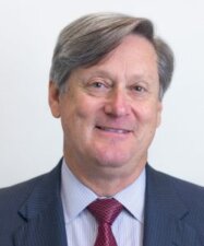 A smiling person with gray hair in a suit and red tie represents Medbridge's professional digital healthcare innovations.