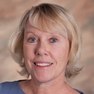 A smiling woman with short blonde hair and blue eyes, symbolizing modern digital healthcare, appears against a blurred beige background, showcasing medbridge.