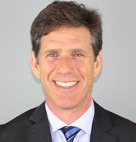 A smiling man in a suit represents digital healthcare innovation, aligning with Medbridge values.