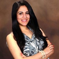 A confident person with long dark hair smiles against a brown background, symbolizing the approachable nature of digital healthcare solutions like medbridge.