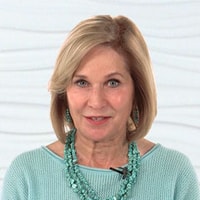 A woman with short blond hair wearing a turquoise necklace and sweater, set against a white textured background for medbridge.