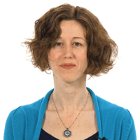Individual with curly brown hair in a blue top, wearing a necklace, set against a white background.
