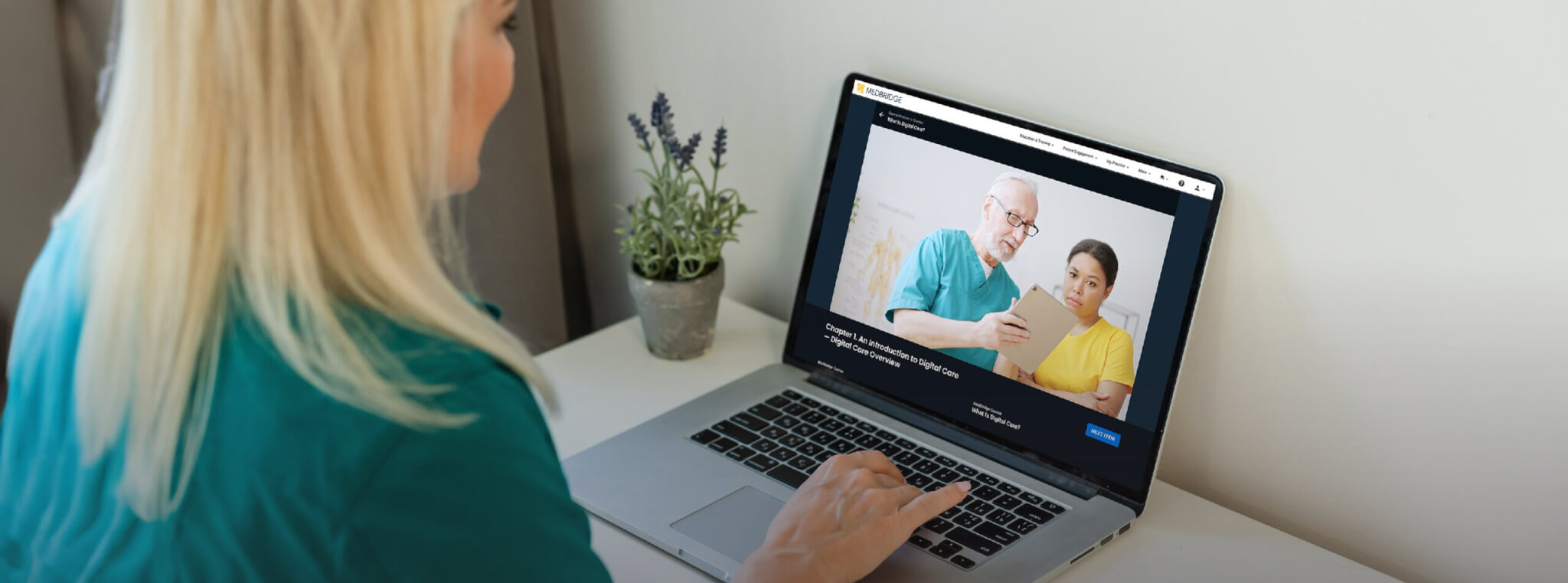 Individual using a laptop with the medbridge logo, next to a small potted plant.