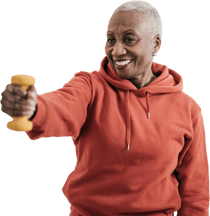 A person in a red hoodie holds a yellow dumbbell, smiling.